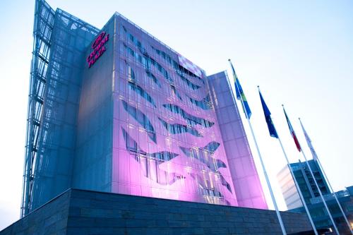 a tall building with pink lights on it at Crowne Plaza Verona Fiera by IHG in Verona