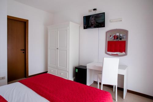 una camera con letto, tavolo e specchio di Hotel Picobello Pineta a Lido di Jesolo