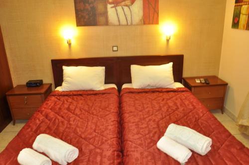 a bedroom with a large bed with two pillows at Corfu Studios Stavroula - San George Apartments in Agios Georgios Pagon