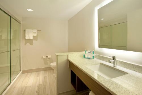 ein Badezimmer mit einem Waschbecken, einem WC und einem Spiegel in der Unterkunft Holiday Inn Express Hotel & Suites Austin Downtown - University, an IHG Hotel in Austin