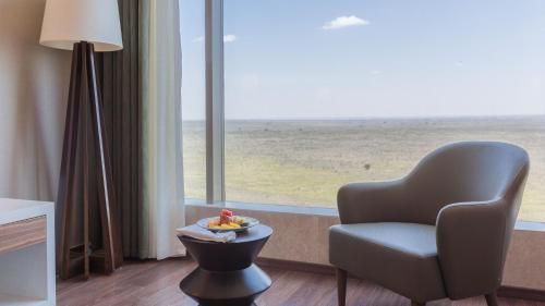 a room with a chair and a table and a window at Emara Ole-Sereni in Nairobi