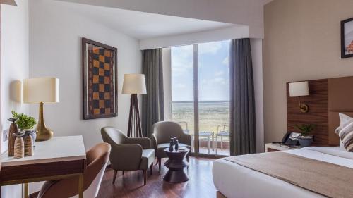 a hotel room with a bed and a desk and chairs at Emara Ole-Sereni in Nairobi