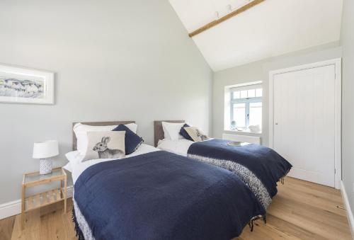 - une chambre avec 2 lits et des couvertures bleues dans l'établissement Stapleford Farm Cottages, à Beaminster