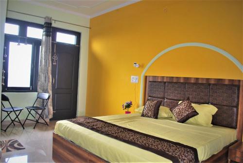a bedroom with a large bed with a yellow wall at BillingVista Guest House Bir in Bīr