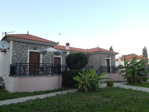 een huis met een balkon met een paraplu bij Kalloni village apartments in Skala Kallonis