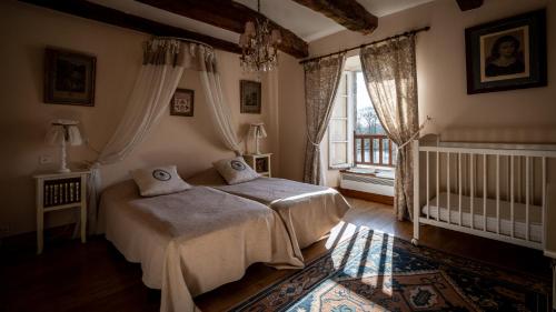 a bedroom with a bed and a crib and a window at Manoir du Plessix Méen in Pluduno