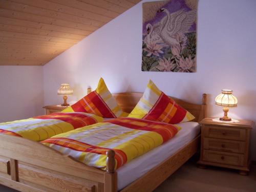 a bedroom with two beds with colorful pillows at Haus Schmid in Innernzell