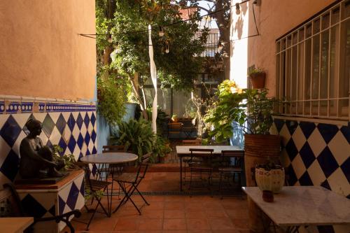 an outdoor patio with tables and chairs and plants at 1900 B&B Terrassa in Terrassa