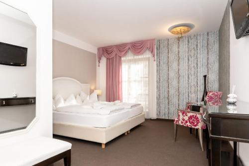 a bedroom with a large white bed and a window at Hotel Villa Groff in Ora/Auer