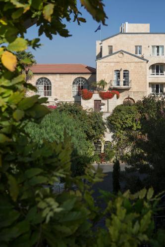 a building with a flag on top of it at The American Colony Hotel - Small Luxury Hotels of the World in Jerusalem