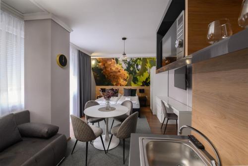 a kitchen and living room with a table and a couch at Angyal Panzió in Hajdúszoboszló