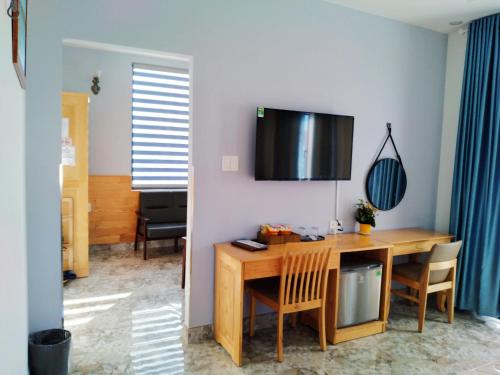 a dining room with a table and a television on the wall at Luan'S Villa in Da Lat