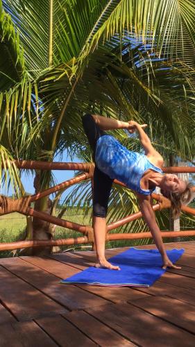 a woman doing a yoga pose on a blue mat at Casa Hridaya Hotel Boutique in Holbox Island