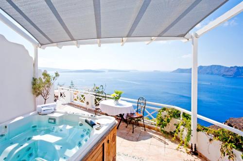 a beach with a balcony overlooking the ocean at Alexander's Suites in Oia