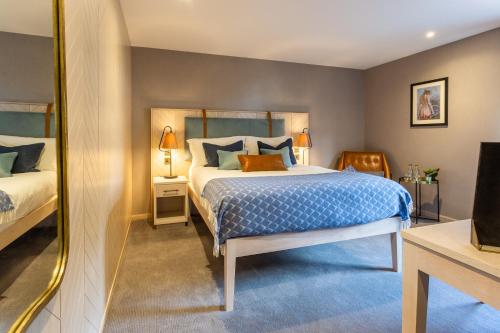 a bedroom with a bed and a mirror at Palm Court Hotel in Aberdeen