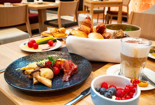 a table with a plate of food and a bowl of fruit at Hotel Stadtpalais in Cologne