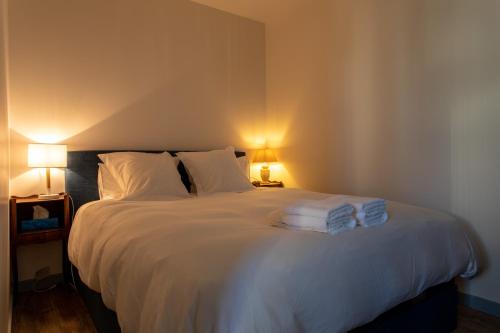 - une chambre avec un lit blanc et des serviettes dans l'établissement Le « 24th » on Blum Square, à Puteaux