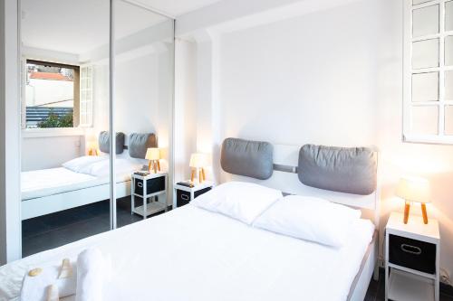 une chambre blanche avec un lit et un miroir dans l'établissement Chez Dominique - 1 chbre 2-4pers Centre Antibes Migrainier Ancien with AC, à Antibes
