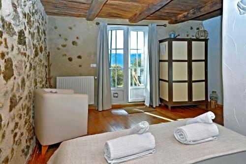 um quarto com uma cama e uma grande janela em Malia - Chambres d'hôtes & Gîte em Barret-de-Lioure