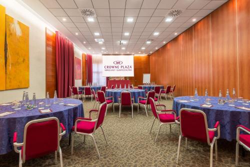 a conference room with blue tables and red chairs at Crowne Plaza Venice East by IHG in Quarto dʼAltino