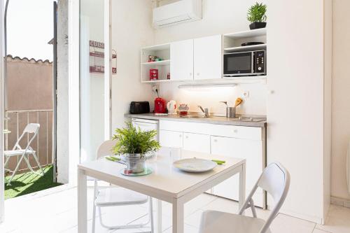 une petite cuisine avec une table et des chaises dans l'établissement Chez Dominique - Studio 2-4pers centre Antibes Fourmilliere 1er, à Antibes