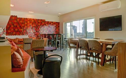 a restaurant with tables and chairs and a large window at Hotel Spot Family Suites in Porto