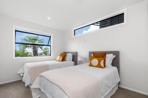En eller flere senge i et værelse på Stylish Villa Escape - Matakana Holiday Home