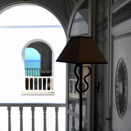 a lamp in a room with a view of the ocean at VILLA EDO in Gammarth