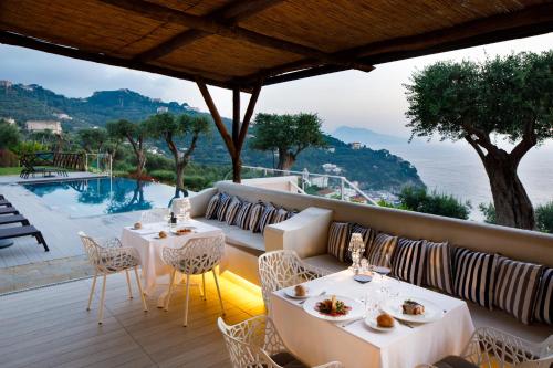 マッサ・ルブレンセにあるVilla Fiorella Art Hotelのパティオ(テーブル、椅子付)、プールが備わります。