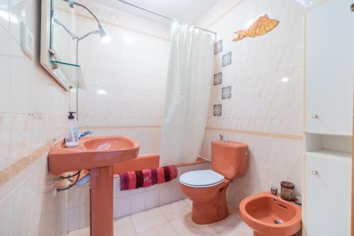 y baño con lavabo rosa y aseo. en Apartamento del Mar San Jose, en San José