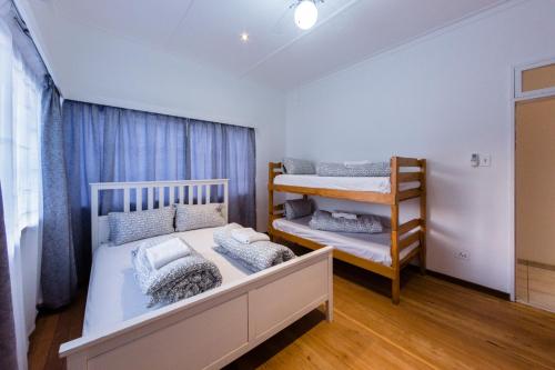 a bedroom with two bunk beds and a ladder at Back2Roots Backpackers in Windhoek