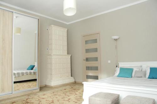 una camera bianca con letto e specchio di Flat in cottage close to the centre parking, WiFi, BBQ a Lviv