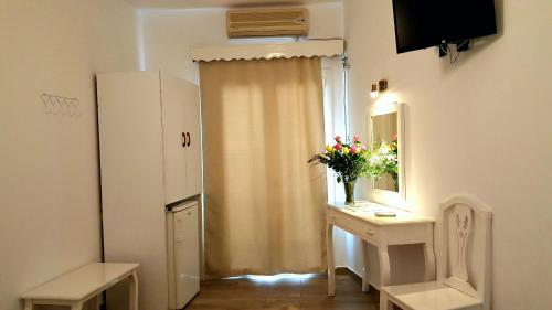 a room with a table with a vase of flowers on it at Villa Pavlina in Karterados