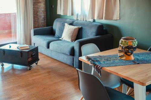 a living room with a table and a blue couch at Mansarda Relax Wellness Gym & Spa in Taormina
