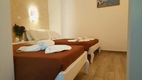 a hotel room with two beds with towels on them at Villa Pavlina in Karterados