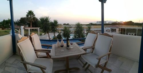 a table and chairs on a balcony with a view at Aeraki Studios in Kastraki Naxou