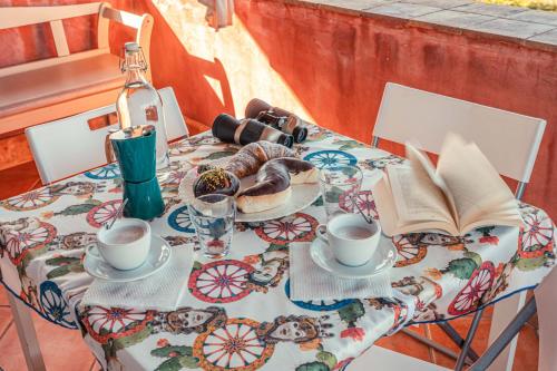 a table with coffee cups and a book on it at Mansarda Relax Wellness Gym & Spa in Taormina