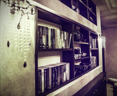 a book shelf with books on it with books at Eliton Hotel & Spa in Kato Loutraki