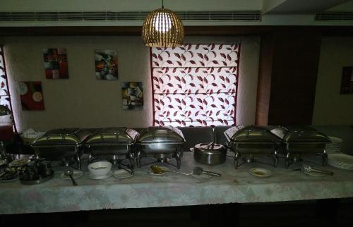 a table with a bunch of pots and pans at KGA Elite Continental Hotel in Thiruvalla