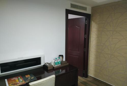 a room with a door and a desk with a mirror at KGA Elite Continental Hotel in Thiruvalla