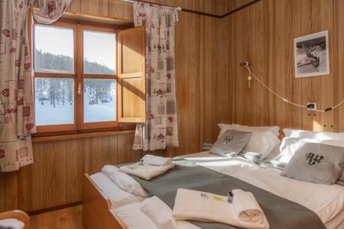1 dormitorio con 2 camas y ventana en Hotel Monte Triplex, en Sauze dʼOulx
