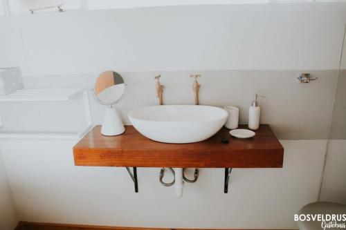y baño con lavabo sobre una mesa de madera. en Bosveldrus Gastehuis, en Vaalwater