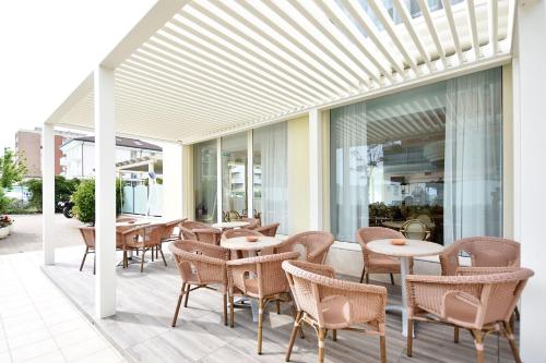 an outdoor patio with tables and chairs and windows at Hotel Europa in Misano Adriatico