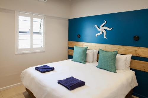 a bedroom with a large white bed with blue walls at Plett Beachfront Accommodation in Plettenberg Bay