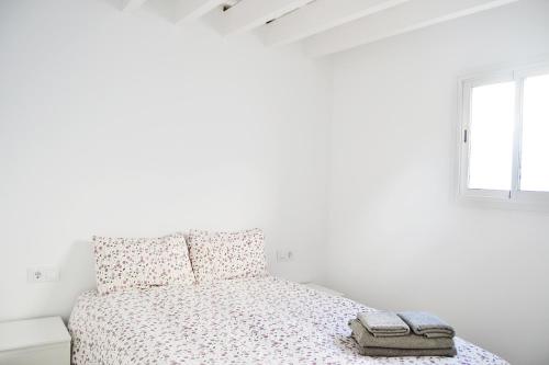 a white bedroom with a bed and a window at Campo del Sur - Catedral in Cádiz
