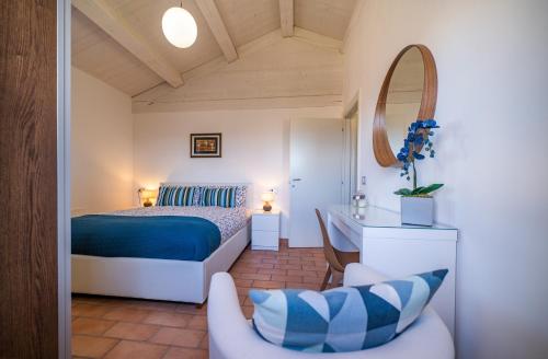1 dormitorio con cama, silla y espejo en Country House Ca' Brunello en Urbino