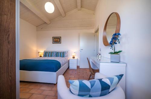 una camera da letto con un letto, una sedia e uno specchio di Country House Ca' Brunello a Urbino