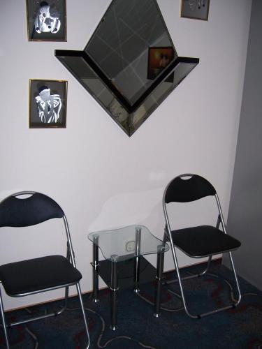 two chairs and a glass table and a mirror at Haus Schmid in Innernzell