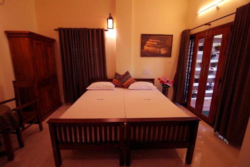 a room with a table and a bed in it at Nirrvaan homestay in Varkala