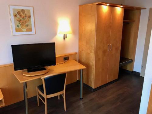 a room with a desk with a computer and a cabinet at Annas Gästehaus in Hallerndorf